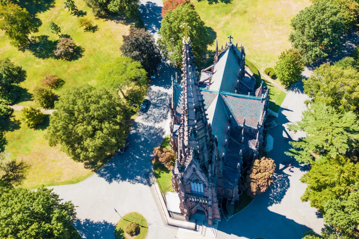 Aerial view of a Gothic-style cathedral surrounded by trees.
